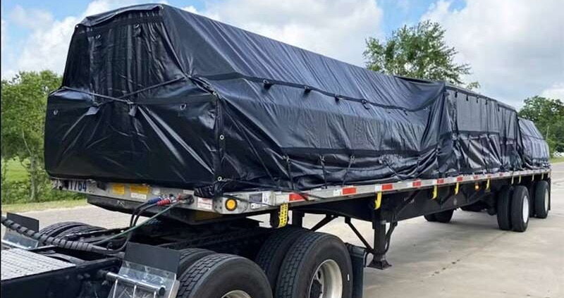 3-piece flatbed tarp set protecting lumber load in heavy rain